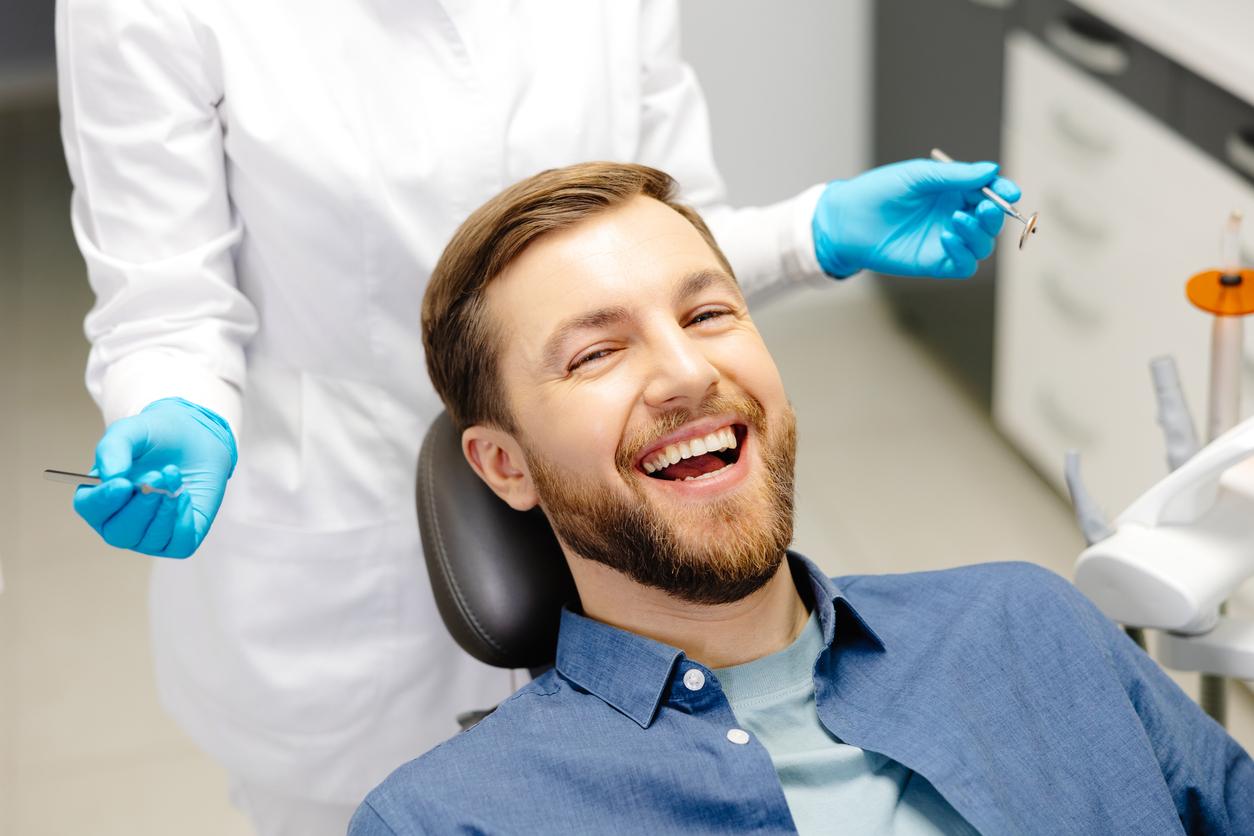 A man who is about to get a dental cleaning smiling in a dental chair A man who is about to get a dental cleaning smiling in a dental chair