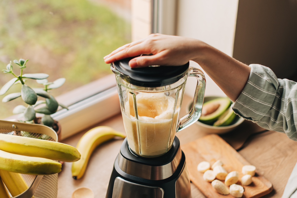 A person making a smoothie after wisdom teeth removal with bananas and avocado